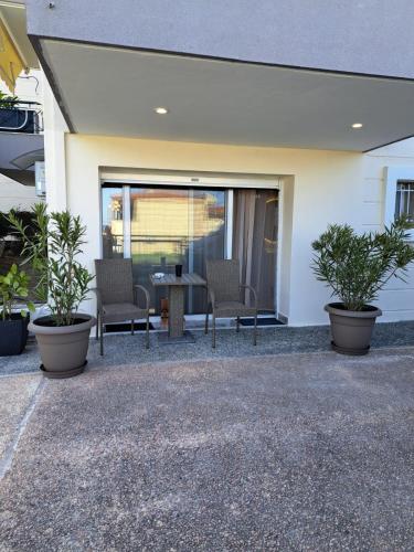 a patio with two chairs and a table with plants at Good Holiday in Kallithea Halkidikis