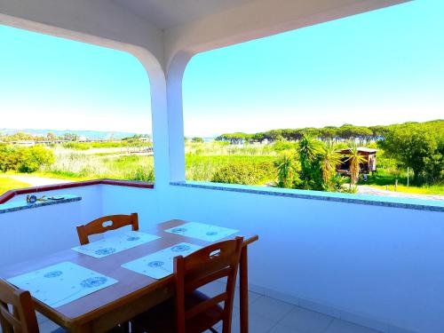 a dining room with a table and two windows at DreamHouse Miramare in Budoni