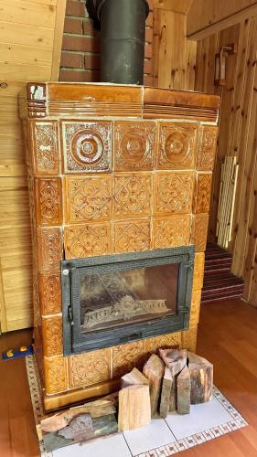 a woodburning fireplace in a room with some logs at Jaśminowy ogród in Brenna