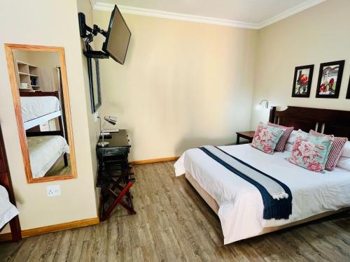 a hotel room with a bed and a mirror at 17 on Bird Guest House in Beaufort West