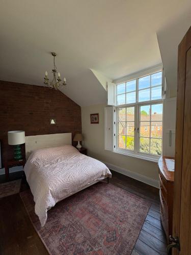 a bedroom with a bed and a large window at Cosy Cottage in Melbourne in Melbourne