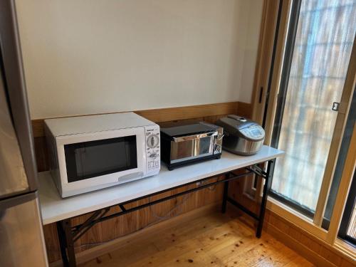 a microwave and a toaster oven on a table at 宿かりん in Yamaga