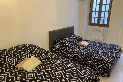 a bedroom with a bed with a black and white comforter at Le Grand Sénat - 55m2 in Chambéry