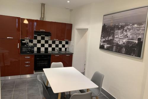 - une cuisine avec une table blanche et des chaises dans l'établissement Le Grand Sénat - 55m2, à Chambéry