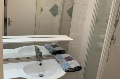 a bathroom sink with two towels and a shower at Le Grand Sénat - 55m2 in Chambéry