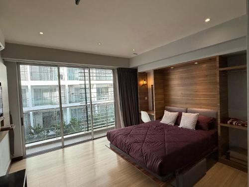Un dormitorio con una cama y una ventana grande. en Cosy Residence Homestay 2, en Kota Kinabalu