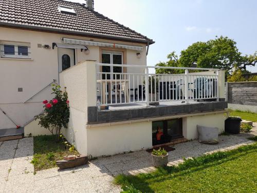 une maison avec un balcon et une cheminée dans l'établissement Chambre sérénité, à Moult