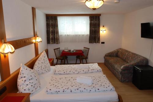 a living room with two beds and a couch at Gästehaus Alpenruh in Holzgau