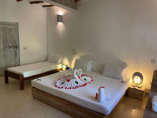 a bedroom with two beds with a cake on it at Mawe Zuri Resort in Watamu
