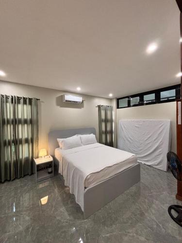 a bedroom with a large white bed and a window at JCPM Apartment Suite-3rd Floor in Santa Cruz
