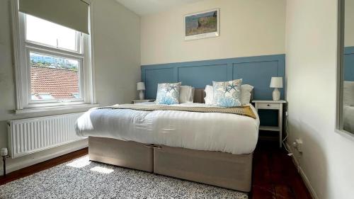 a bedroom with a large bed with a blue headboard at St James Dairy in Ilfracombe
