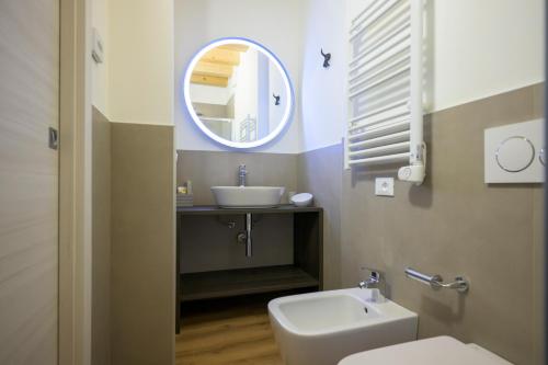a bathroom with a sink and a toilet and a mirror at La Còrt Apartments - Number 2 in Manerba del Garda
