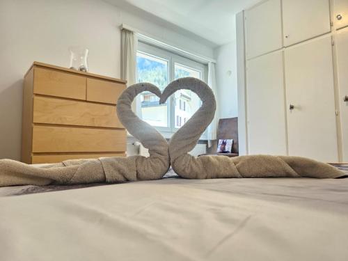 two swans shaped like a heart sitting on a bed at Leukerfun in Leukerbad