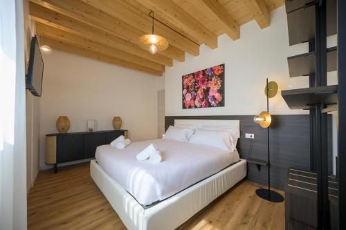 a bedroom with a large white bed in a room at La Còrt Apartments - Number 2 in Manerba del Garda