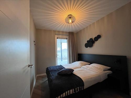 a bedroom with a bed with a light on the ceiling at EuroParcs De IJssel Eilanden in Kampen
