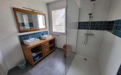 une salle de bain avec un lavabo et une douche avec un miroir dans l'établissement A 900 mètres de la plage de Kerhillio Maison lumineuse pour 6 personnes, à Erdeven