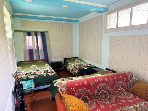 a living room with two beds and a couch at Hayq Guest House in Goris
