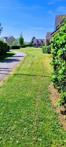 a field of green grass next to a road at Your 4 Bedroom Townhouse - Superking Bed in Stamford