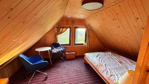 a bedroom with a bed and a chair in a room at Jaśminowy ogród in Brenna
