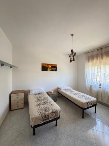 a bedroom with two beds and a window at G&N apartment in Agropoli