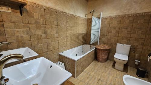 a bathroom with a tub and a toilet and a sink at El Rincon del Castro in Benia
