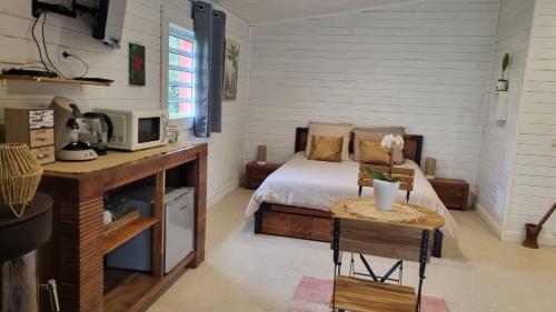 a small bedroom with a bed and a microwave at Le Palmiste Enchanté in La Plaine des Palmistes