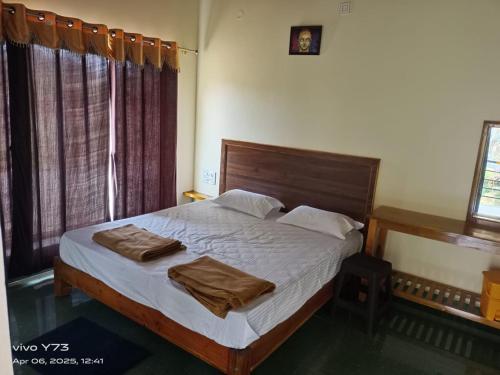a bedroom with a bed with two towels on it at Jolly Homestay in Jog Falls
