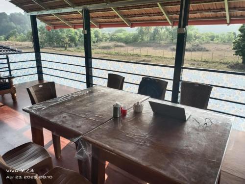 a wooden table with a laptop on top of it at Jolly Homestay in Jog Falls