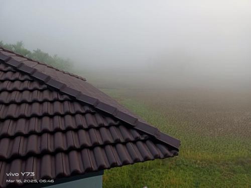 a roof of a house with a field in the background at Jolly Homestay in Jog Falls