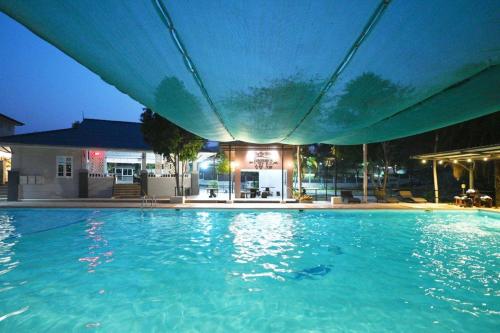 a large swimming pool at night with a hotel at Mina Resort and Spa in Loei