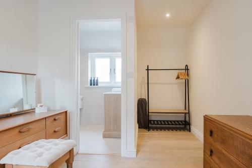 ein Badezimmer mit weißen Wänden, einem Spiegel und einem Waschbecken in der Unterkunft Mulberry Cottage - Stunning 5 Bed in Wiltshire! in Charlton