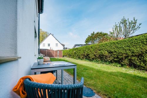 a table and chairs on a patio with a yard at Gasthaus & Pension "Zur Schaabe" in Glowe
