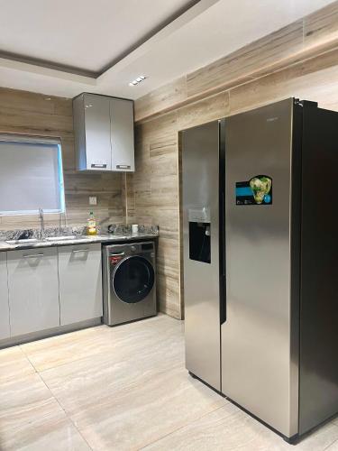 a kitchen with a stainless steel refrigerator and a dishwasher at Creekwood Apartment in Abuja