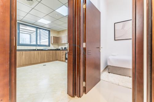 an open door in a room with a kitchen at Sea Views 4BR and Assistant's Room Villa with Private Pool, Sharm - Al Dana Villa, Al Dana Island by Deluxe Holiday Homes in Fujairah