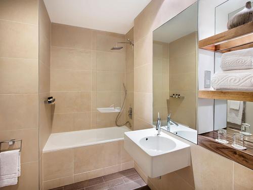 a bathroom with a sink, tub, and shower at Jurys Inn Cardiff in Cardiff