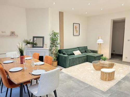 - un salon avec une table et un canapé vert dans l'établissement Le Raffiné Troyes - hypercentre, à Troyes