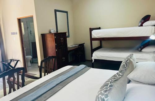 a bedroom with two bunk beds and a mirror at 17 on Bird Guest House in Beaufort West