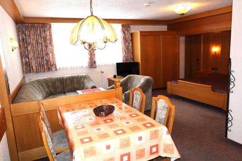 a living room with a table and a couch at Gästehaus Alpenruh in Holzgau