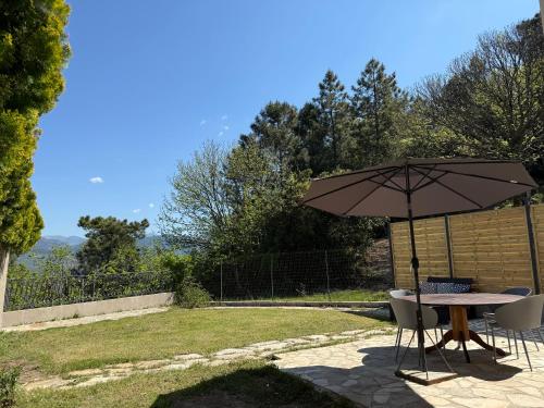 a table and chairs with an umbrella on a patio at Domaine Le Rocher d Argent avec Piscine Extérieur ,Jacuzzi Intérieur et Salle de jeux in Berre-les Alpes