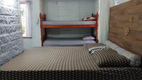 a bedroom with two bunk beds in a room at Casa de campo zona rural- wifi - lareira - in Gravataí
