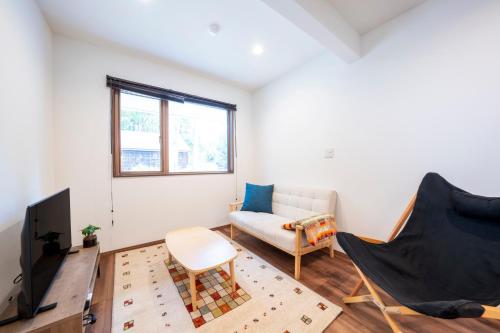 a living room with a couch and a chair at Pension Bonnard in Hakuba