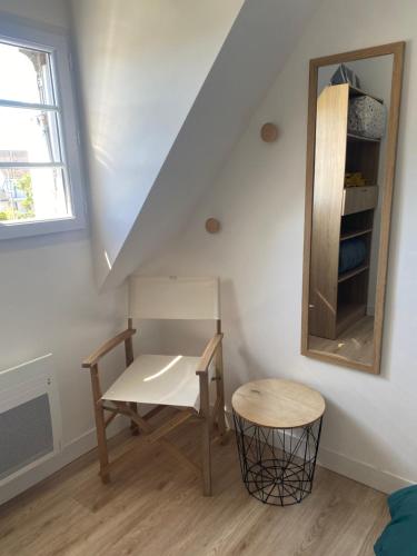 a room with a table and a mirror and a stool at La Brise Marine, calme, Océan, 350m plage in Loctudy