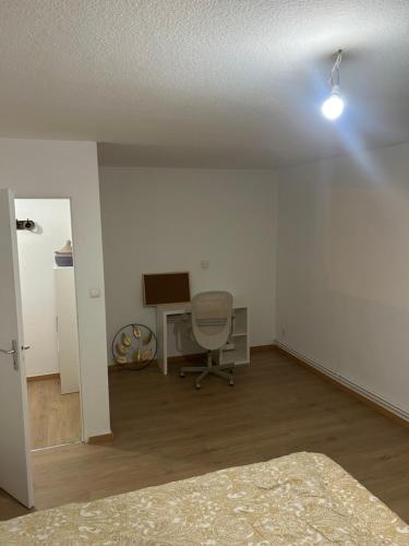une pièce vide avec un bureau et une chaise dans l'établissement Chambre chez l'habitant - Longwy bas, à Longwy