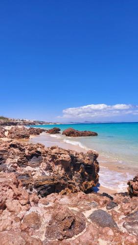 a beach with some rocks and the ocean at Casa Mararía in Gran Tarajal