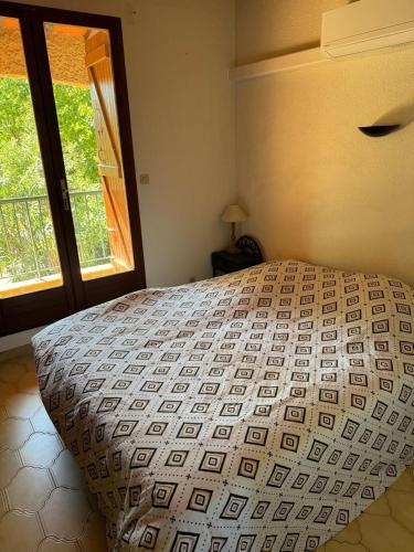 une chambre avec un grand lit avec une fenêtre dans l'établissement Logement bord de mer, à Saint Cyprien Plage