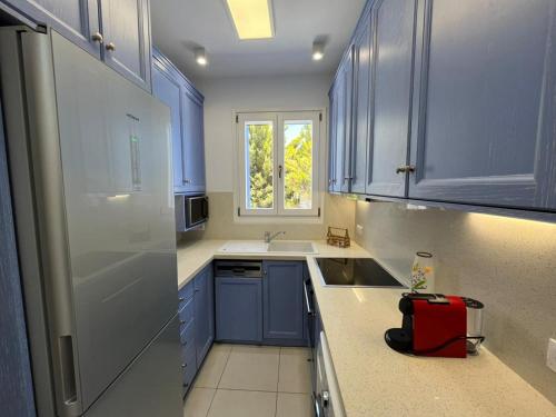 a kitchen with blue cabinets and a red bag on the counter at Villa Santorini Serenity with private Pool in Monolithos