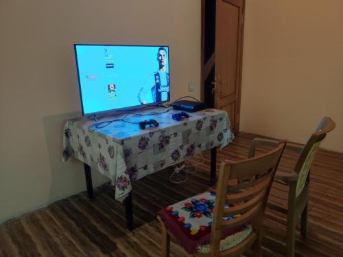 a room with a table with a video game on the screen at The River View Villa الحلال Halal Concept in Quba