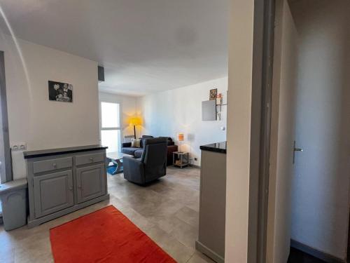a living room with a couch and a red rug at App Centre Port Cap d'Agde Parking in Cap d'Agde