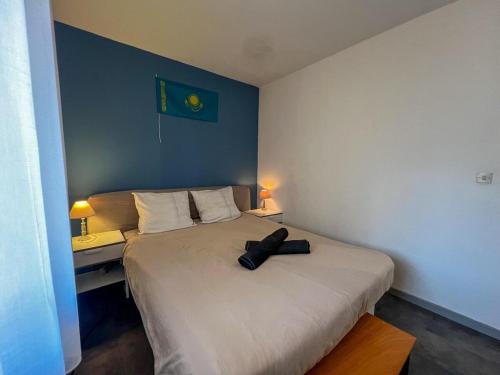 a bedroom with a bed with a hat on it at App Centre Port Cap d'Agde Parking in Cap d'Agde