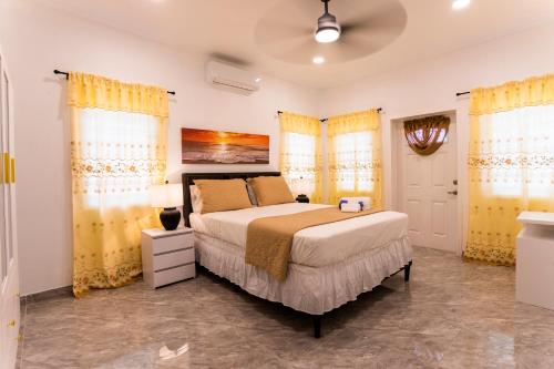 a bedroom with a bed and yellow curtains at Spacious 2 Bedroom Unit with Concierge in Anguilla